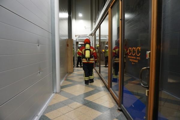 En brandman står i en korridor, sett bakifrån