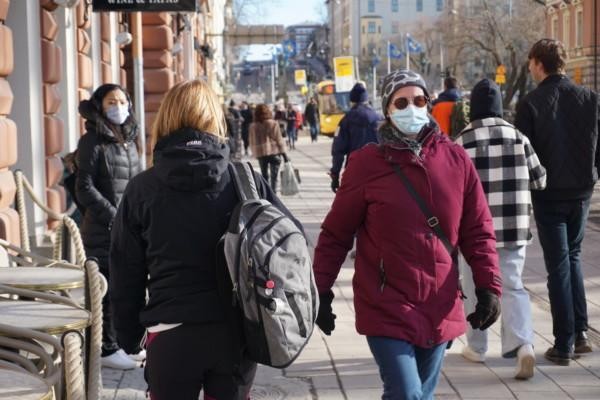 en kvinna med munskydd bland med folk på gatan