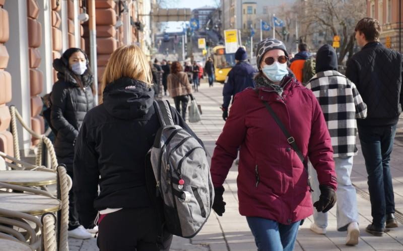 en kvinna med munskydd bland med folk på gatan