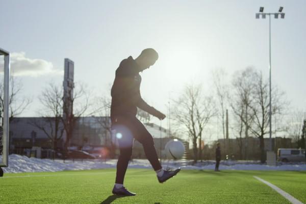 En spelare på en grön fotbollsplan.