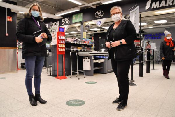 Två kvinnor med munskydd i en affär