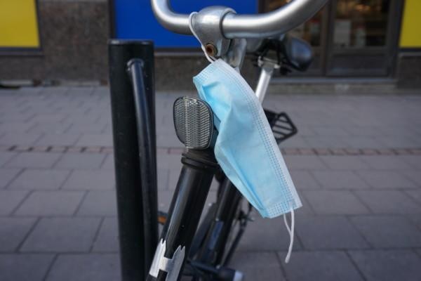 ett munskydd hänger över ett cykelstyre