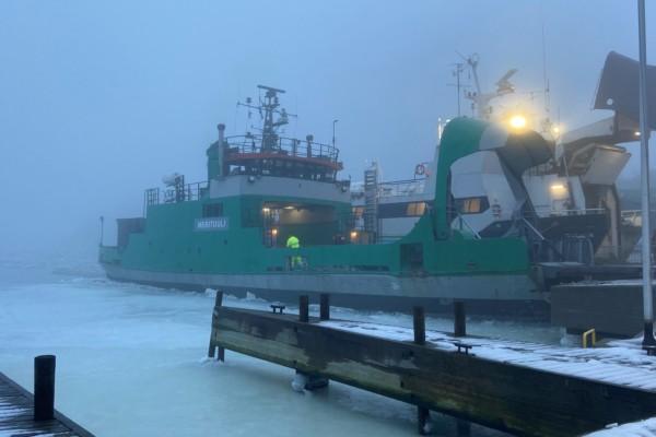 en grön förbindelsebåt i dimman och isen