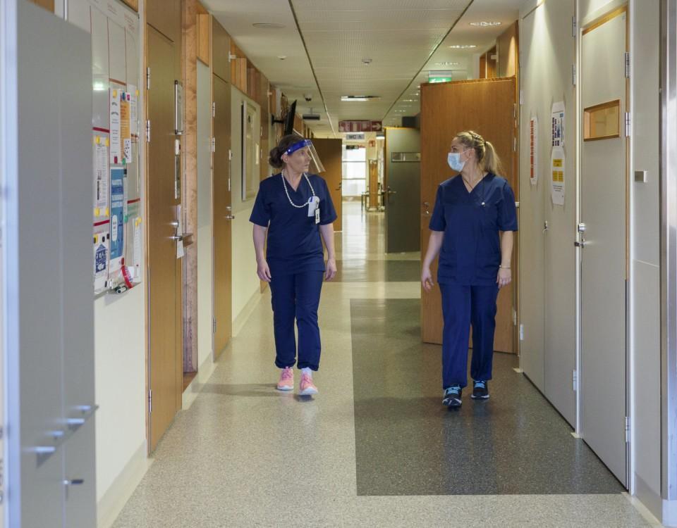 kvinnliga sjukskätare i blå kläder i sjukhuskorridor