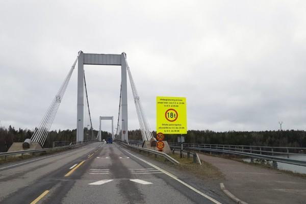 en bro med en stor, gul varningsskylt