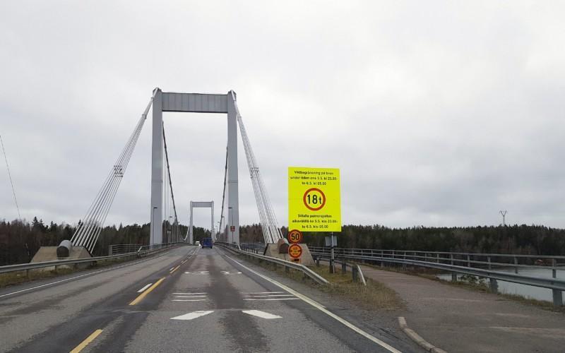 en bro med en stor, gul varningsskylt