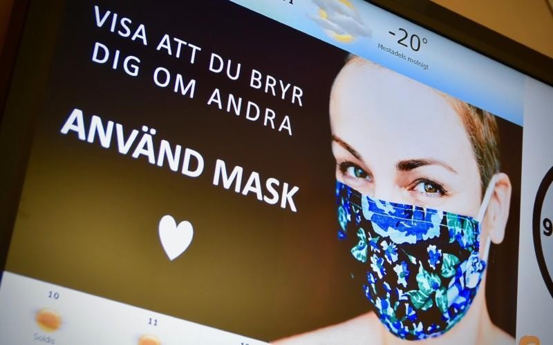 en kvinna med munskudd på en bildskärm med texten "använd mask"