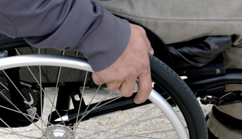 en hand håller om ett rullstolshjul