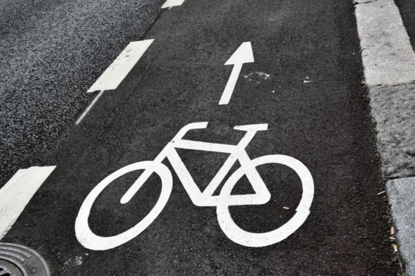 en svart väg med en vit målad cykel på