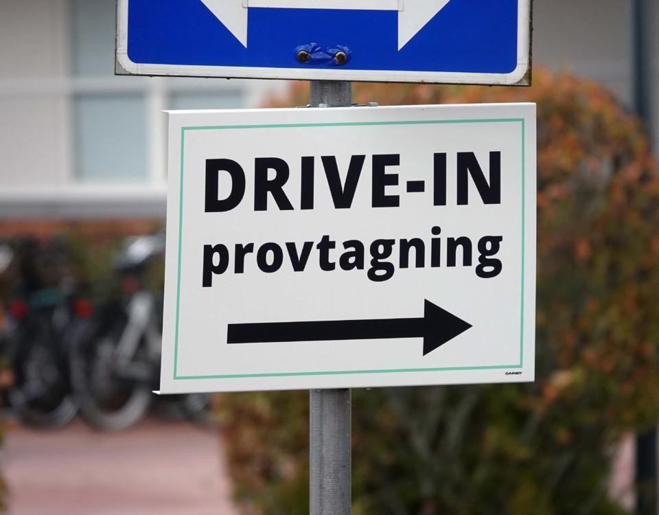 En skylt med en pil och texten "Drive-in provtagning".
