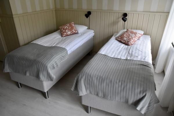 Två sängar i ett hotellrum.
