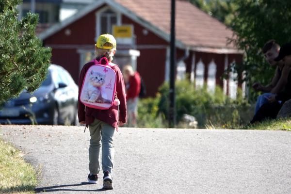 Ett barn med skolväska på ryggen.