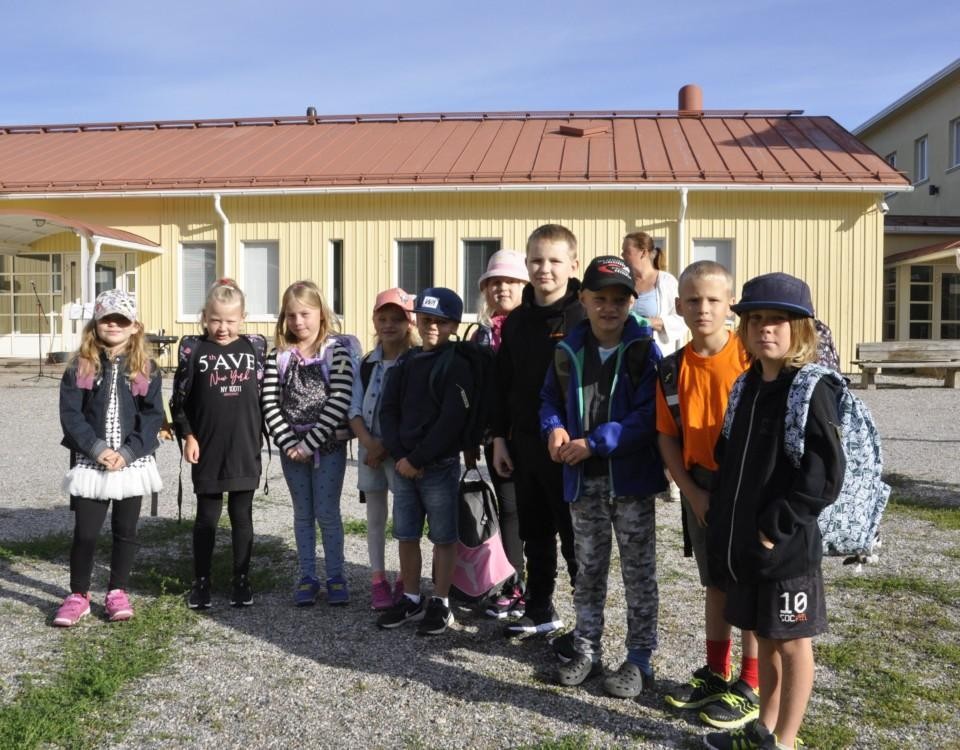 en grupp barn i rad på en skolgård