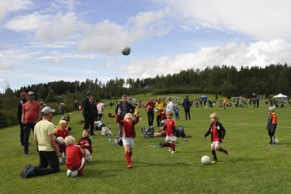 Stor grön plan med många små fotbollsspelare
