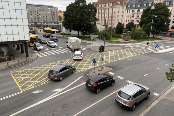 gula rutor målade på vägen i en trafikerad korsning