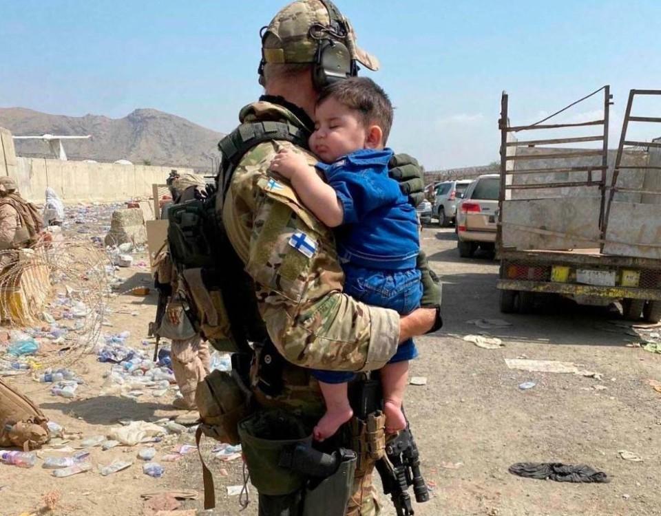 en soldat bär ett barn
