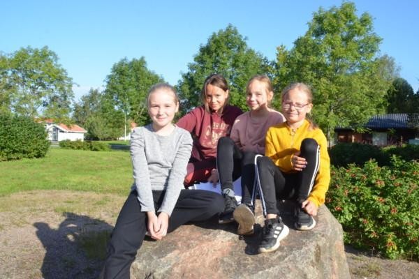 Barn som sitter på en sten.