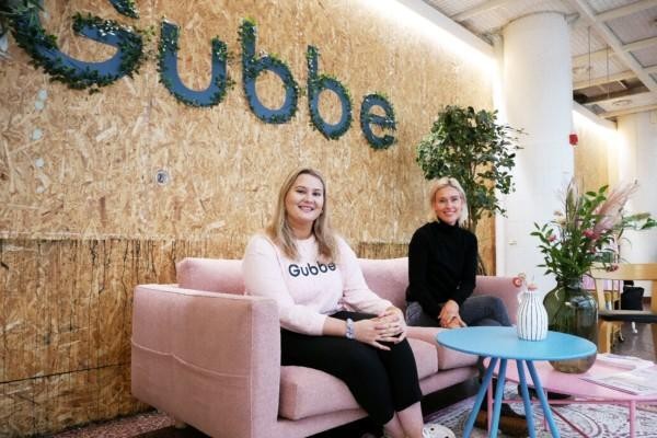 Asumalahti och Laaksonen sitter på en rosa soffa framför en stor Gubbe-logo.