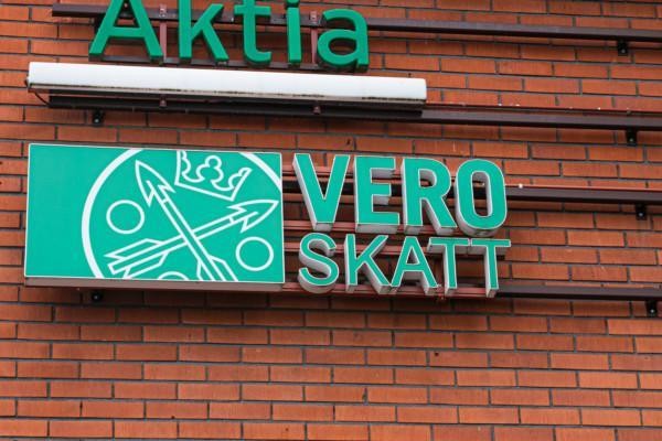 Aktias och Skatteförvaltningens gröna skyltar på röd tegelvägg