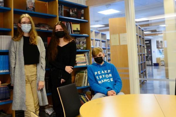 tre elever i ett bibliotek