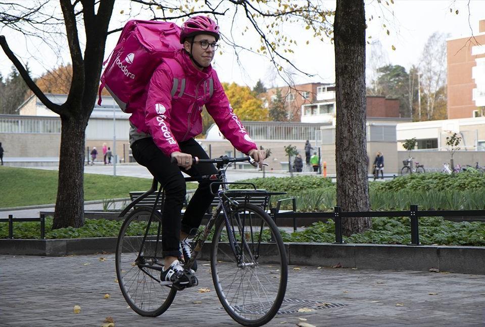 En cyklande man med stor ryggsäck på ryggen.