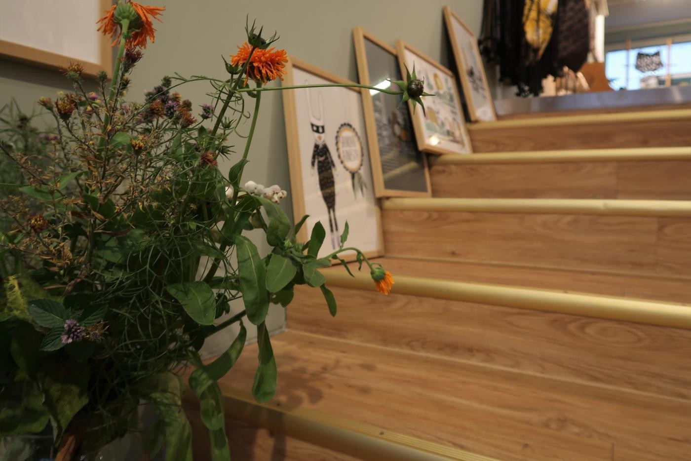Bild av en trappa med tavlor och grönsväxter uppställda.