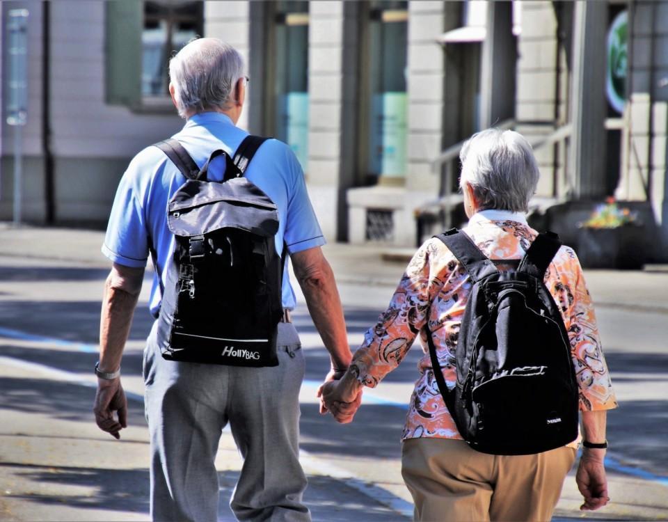 En äldre man och en kvinna som går hand i hand.