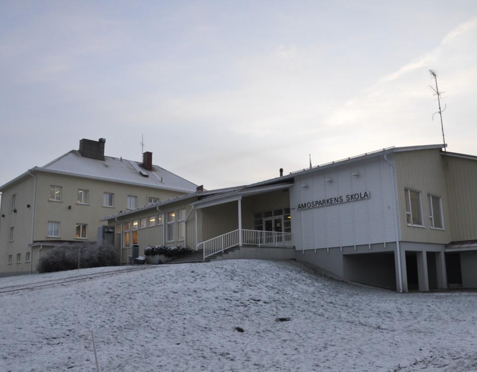 skolbyggnad i vintrigt landskap