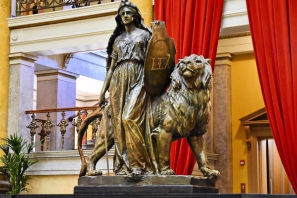ett lejon och en röd gardin och en staty
