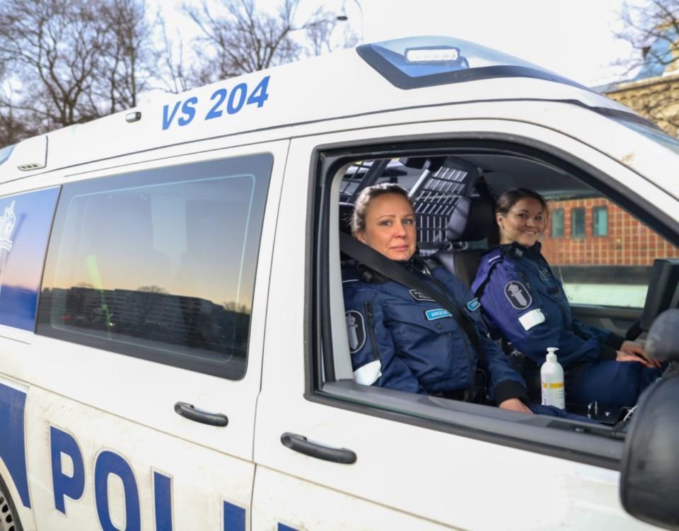 Två poliser i en polisbil.