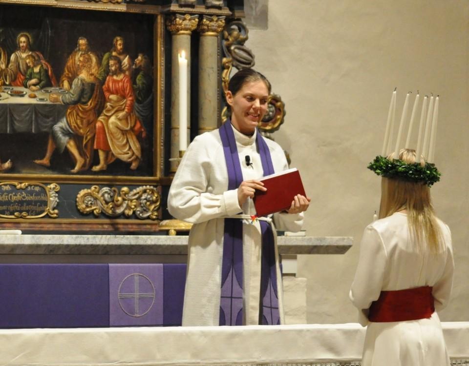 en kvinnlig präst vid altaret