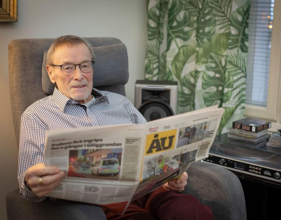 äldre man sitter i fåtölj och läser en tidning, ÅU