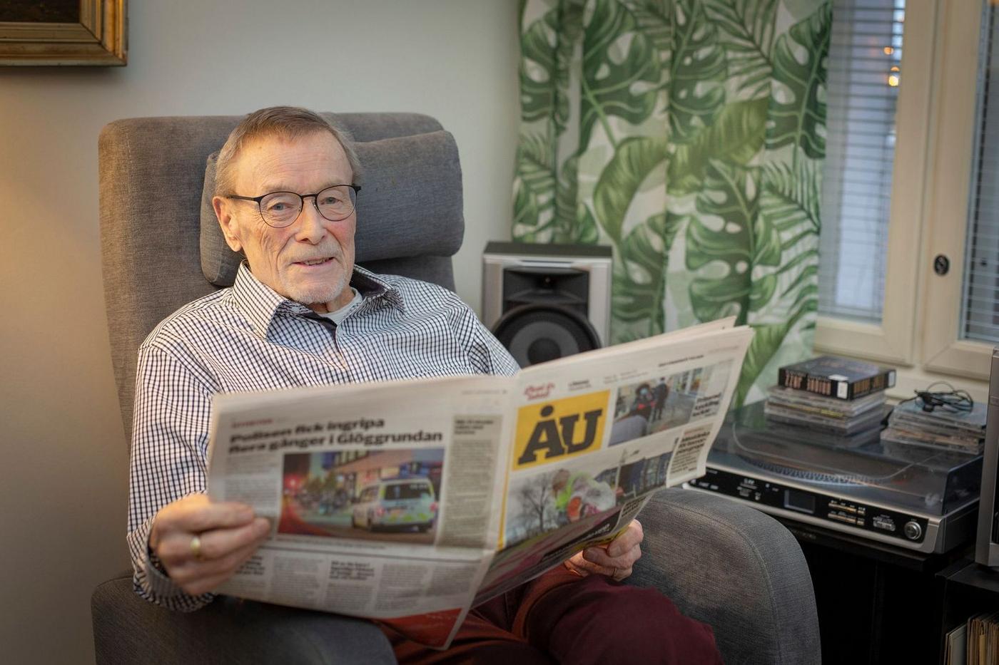 äldre man sitter i fåtölj och läser en tidning, ÅU