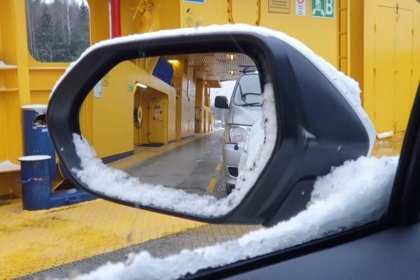 En snöig sidospegel på en bil.