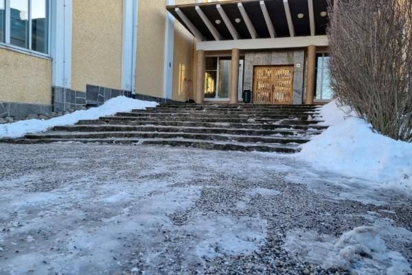 Ingång med trappor till skola på vintern