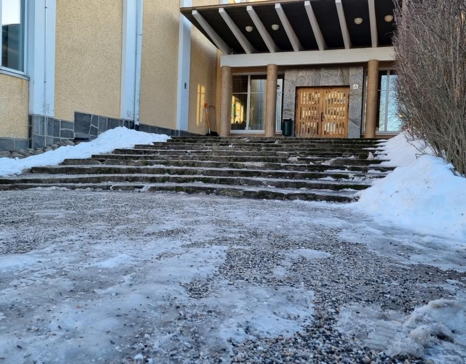 Ingång med trappor till skola på vintern