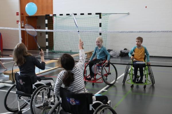 barn i rullstol som spelar med bollar