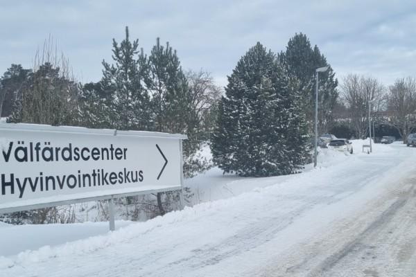 skylt med texten "Välfärdscenter" vid snöig väg