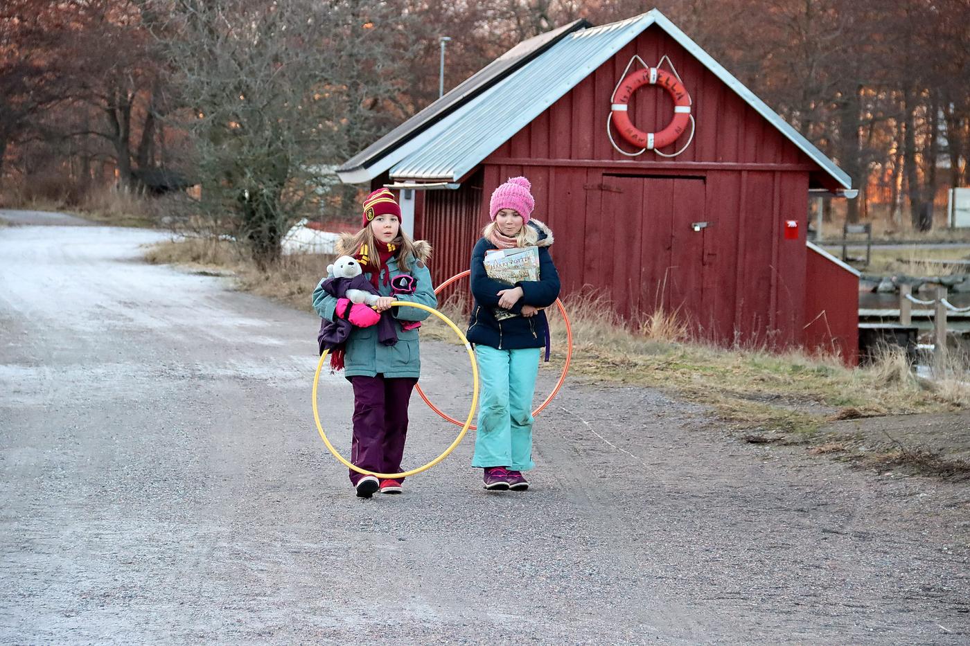 Två flickor som går å en byväg.