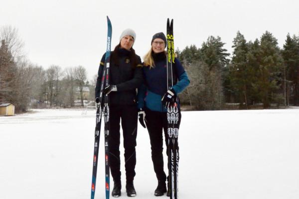 två kvinnor poserar med sina skidor