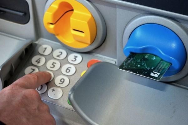 En hand på en bankomats knappsats