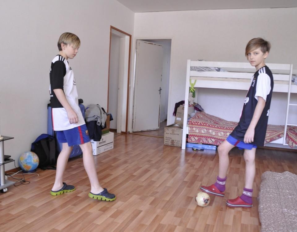 Två pojkar sparkar boll i en lägenhet