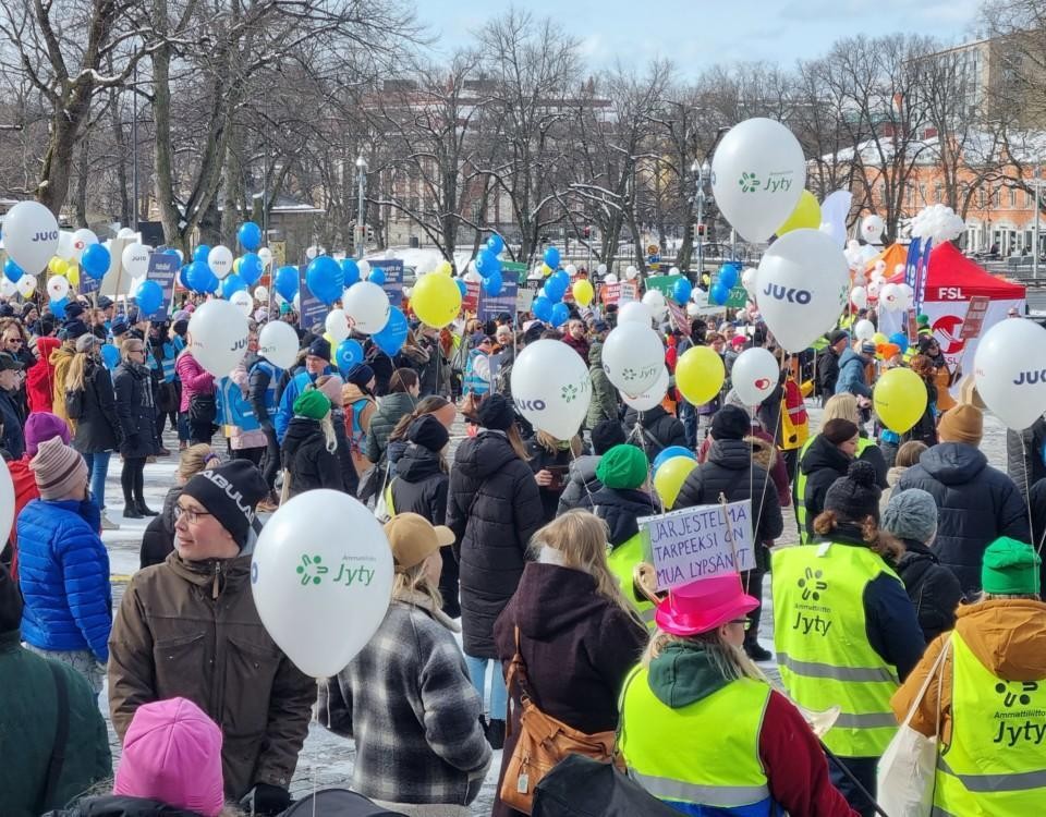 demonstranter i fula västar och med mycket ballonger på ett stort torg