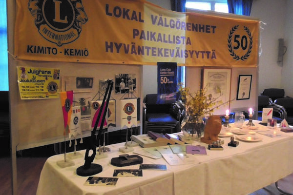 Ett bord med utmärkelser som ska delas ut. Ovanför hänger en banderill med Lions logo och texten "Lokal välgörenhet"