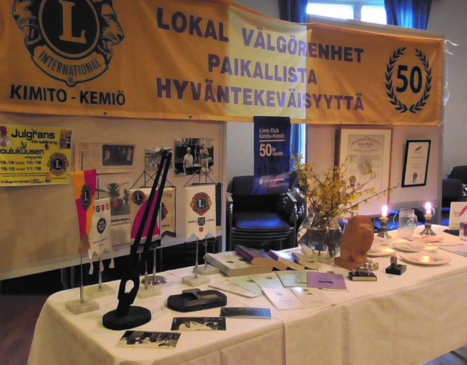 Ett bord med utmärkelser som ska delas ut. Ovanför hänger en banderill med Lions logo och texten "Lokal välgörenhet"