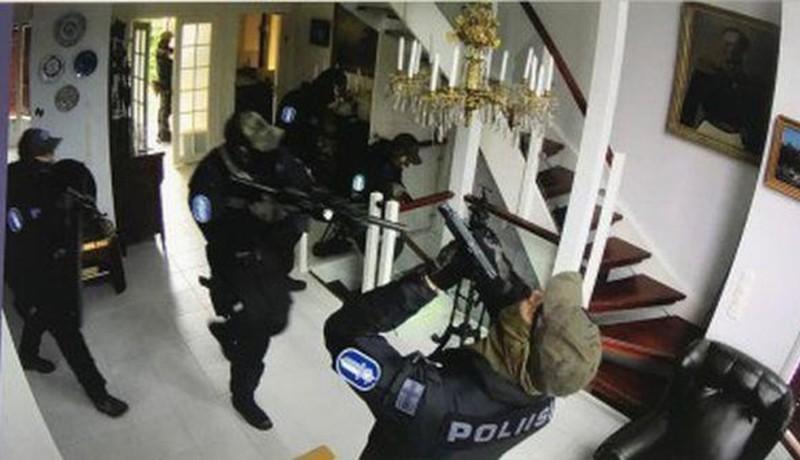 poliser med gevär i ett hus