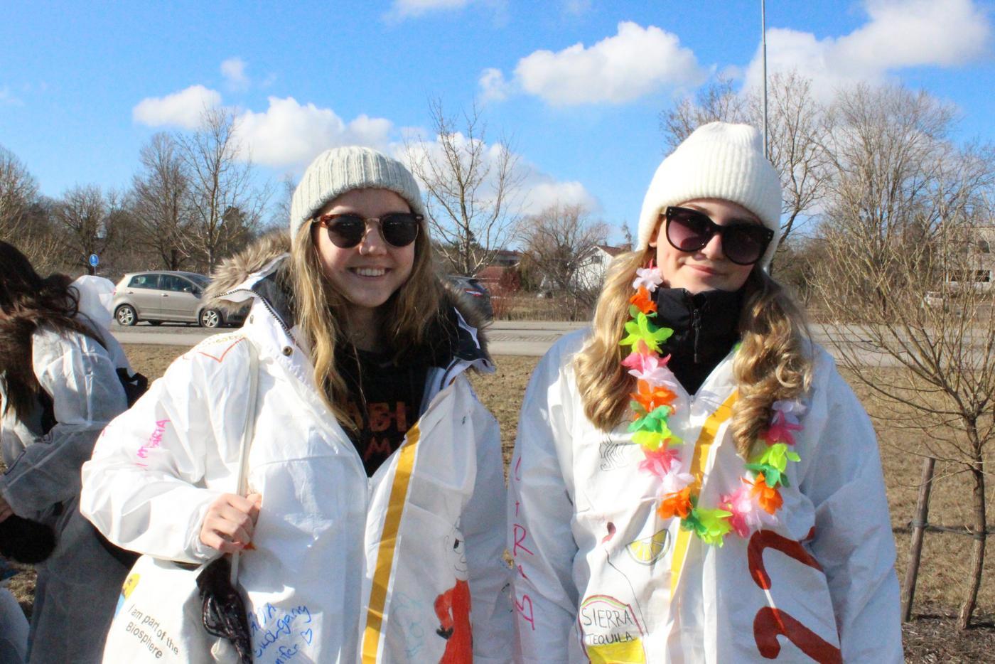 Två unga kvinnor i vita overaller.