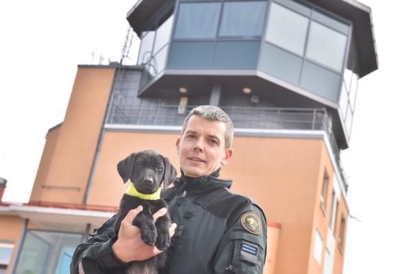 Hund i famnen på man i uniform