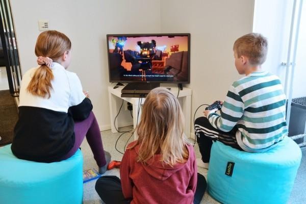 Tre barn spelar videospel
