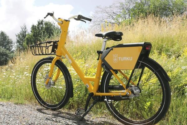 En gul cykel med korg vid sidan av en grusväg.